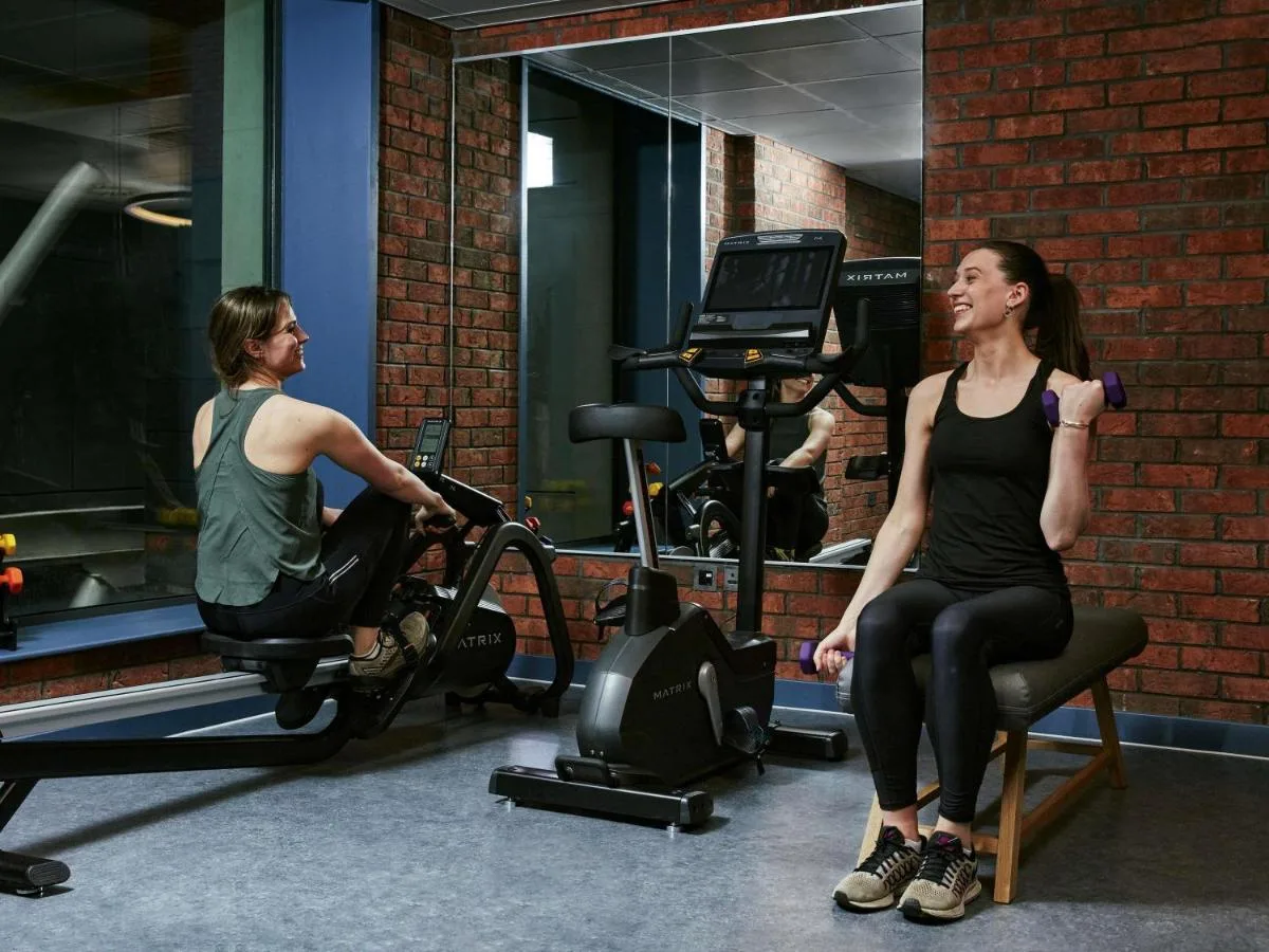 a man and a woman sitting in a gym at Aparthotel Adagio Glasgow Central in Glasgow